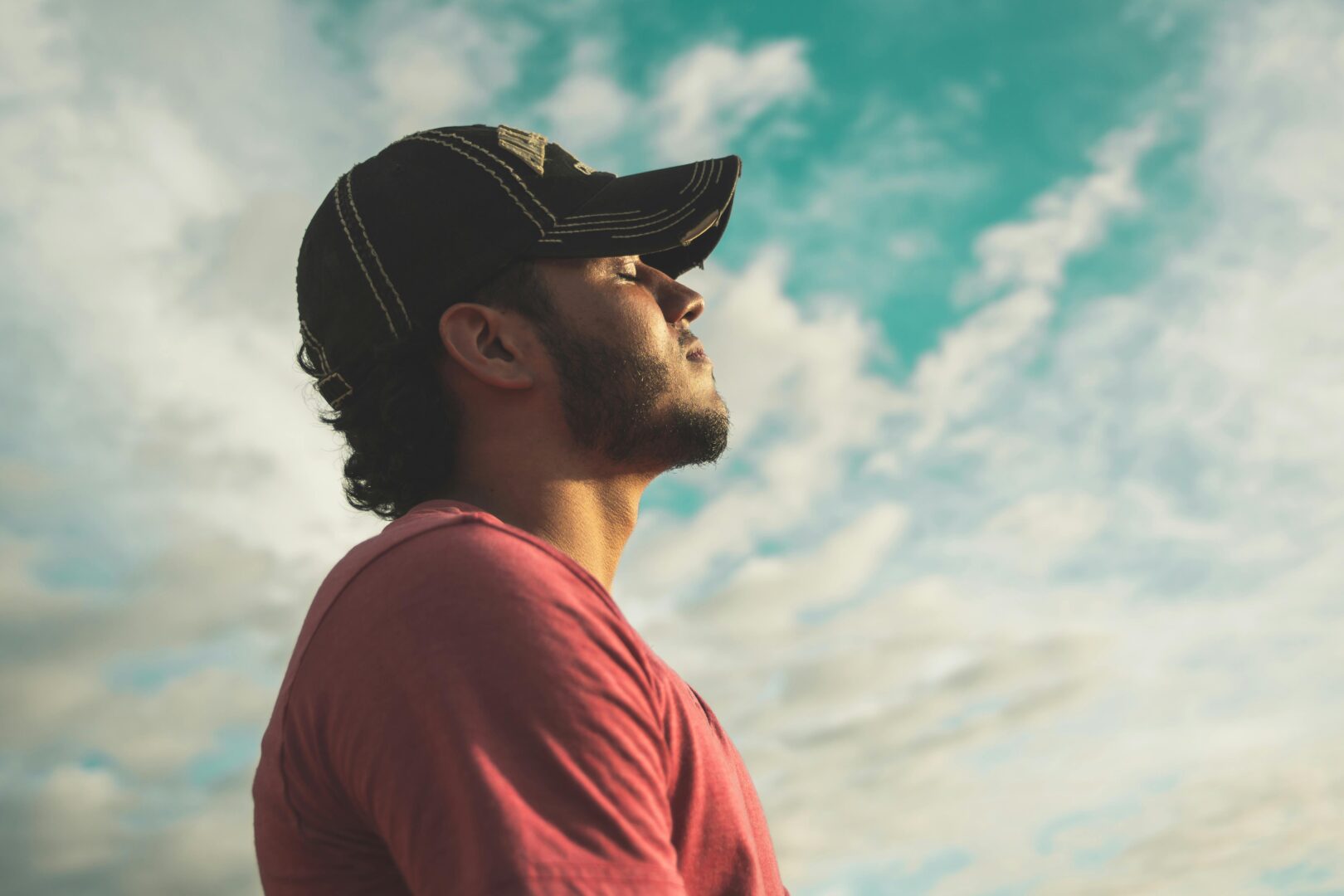 Man calmly inhaling and looking into a blue sky