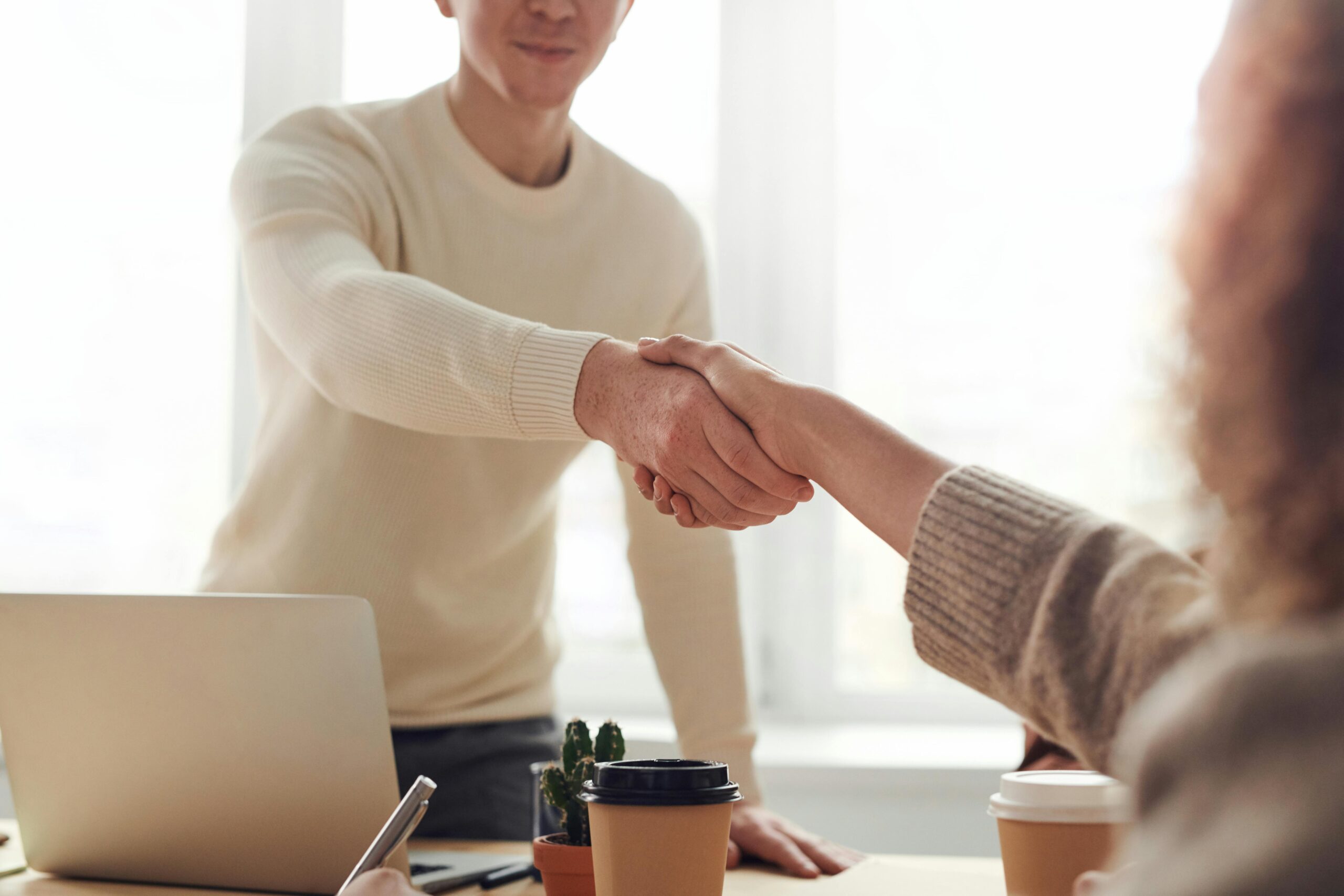 Man shaking a woman's hand from behind a desk